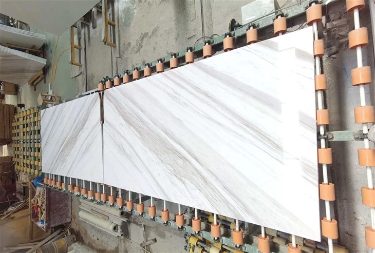 Large-format Ajax Marble slabs with white and soft gray diagonal veining during factory fabrication